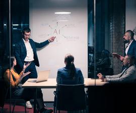 Board room at night with man pointing at large whiteboard 