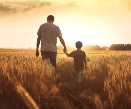 Father Walking Through Field With Son