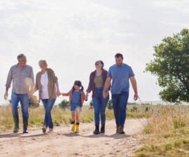 Love, happy family walking holding hands and on a farm with blue sky. Support or care, happiness or agriculture and people walk outdoors by countryside or rural environment together with generation