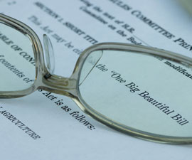 Closeup of the documents of the One Big Beautiful Bill Act (OBBBA) through pair of eyeglasses