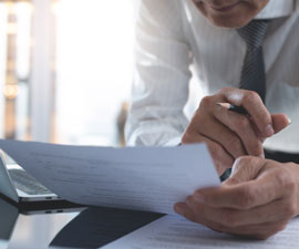businessman reading carefully terms, conditions of business contract at office, close-up 
