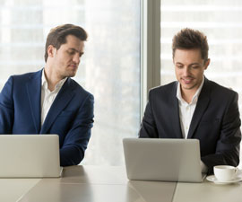 Curious businessman secretly looking at laptop screen of colleague, sneaking peek at other computer, stealing idea