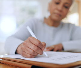 Senior woman, sign and writing with documents, paperwork and application for will in retirement with signature